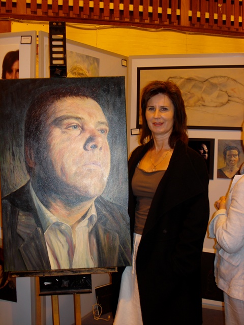 Marie Buchan artist standing beside a large oil painting of Paul Sherrington, principal of Banff and Buchan College 2011